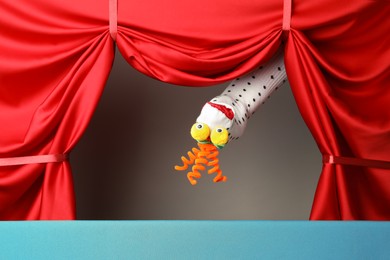 Photo of Creative puppet show on stage with red curtains