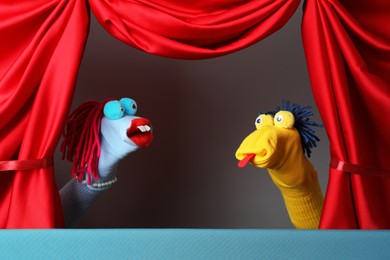 Photo of Creative puppet show on stage with red curtains