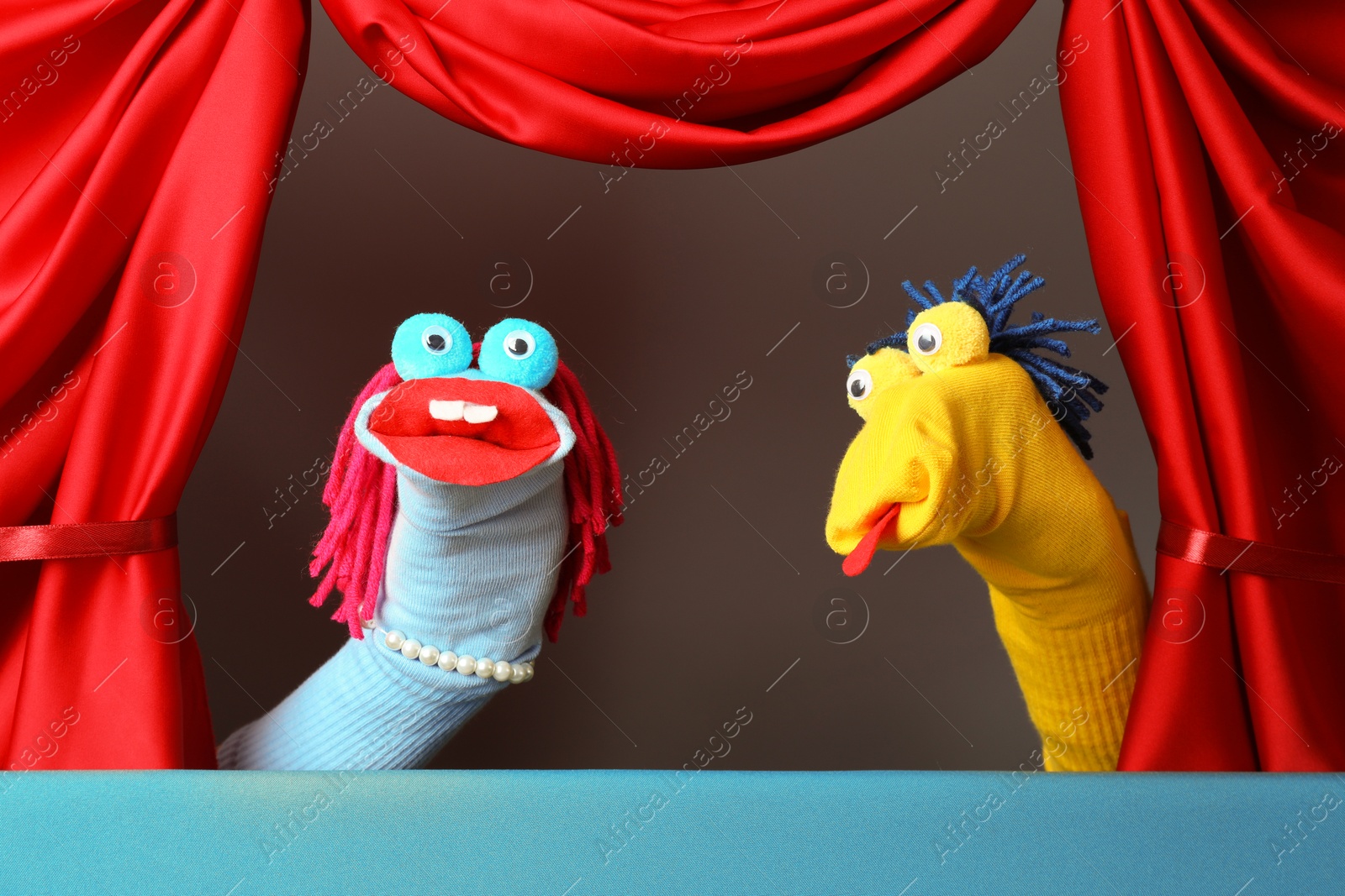 Creative puppet show on stage with red curtains Photo of Creative puppet show on stage with red curtains