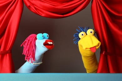 Photo of Creative puppet show on stage with red curtains