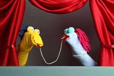 Photo of Creative puppet show on stage with red curtains