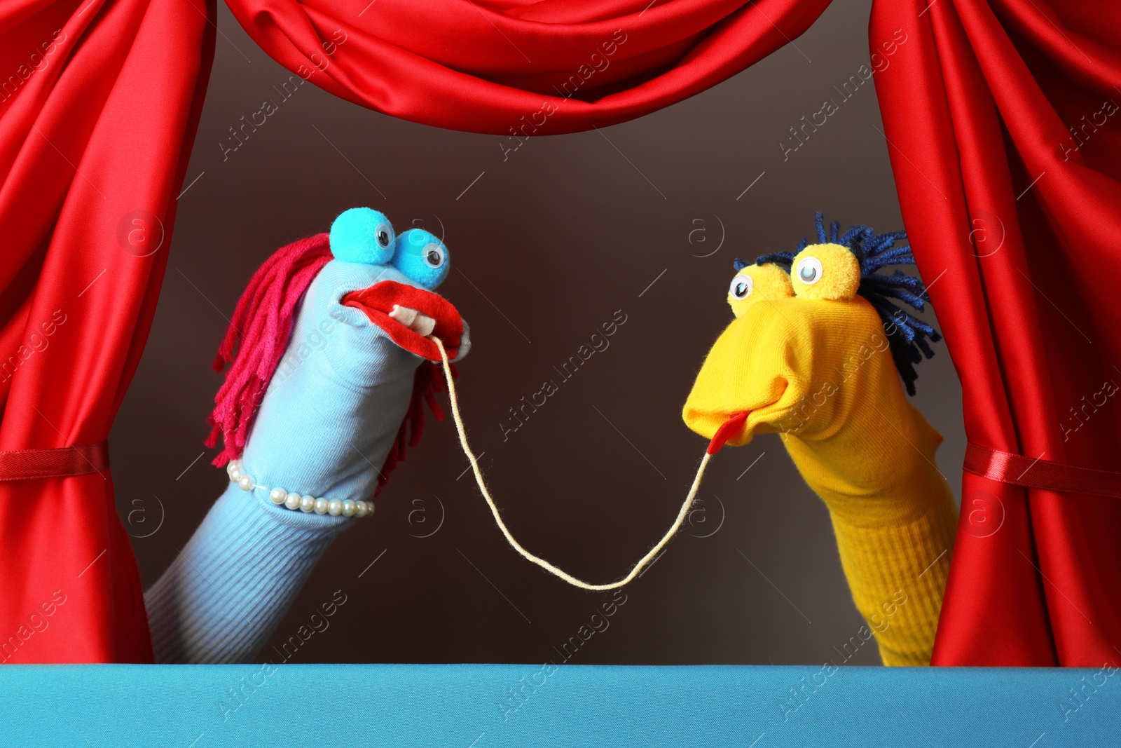 Creative puppet show on stage with red curtains Photo of Creative puppet show on stage with red curtains