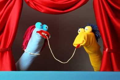 Photo of Creative puppet show on stage with red curtains