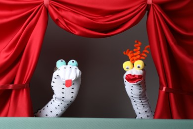 Photo of Creative puppet show on stage with red curtains