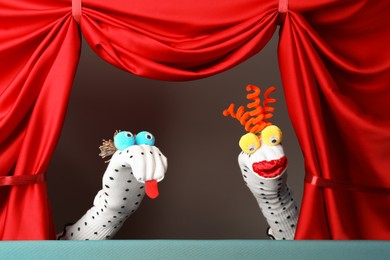 Photo of Creative puppet show on stage with red curtains