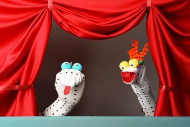 Photo of Creative puppet show on stage with red curtains