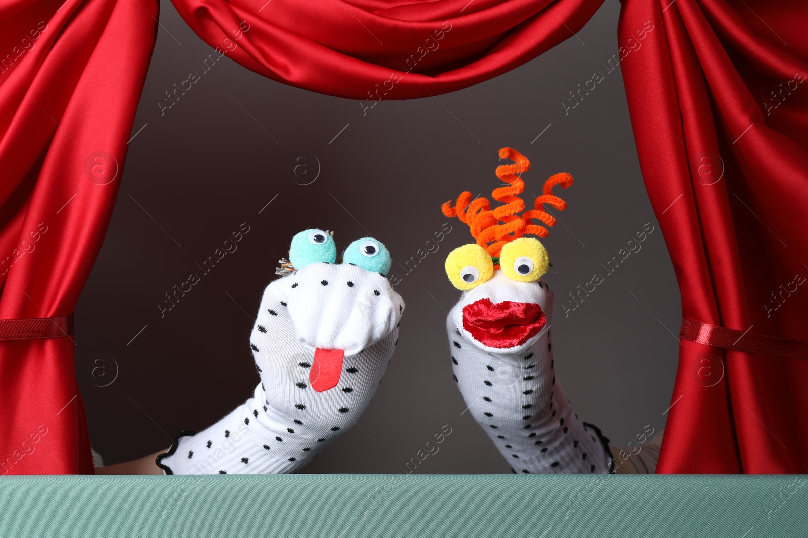 Photo of Creative puppet show on stage with red curtains