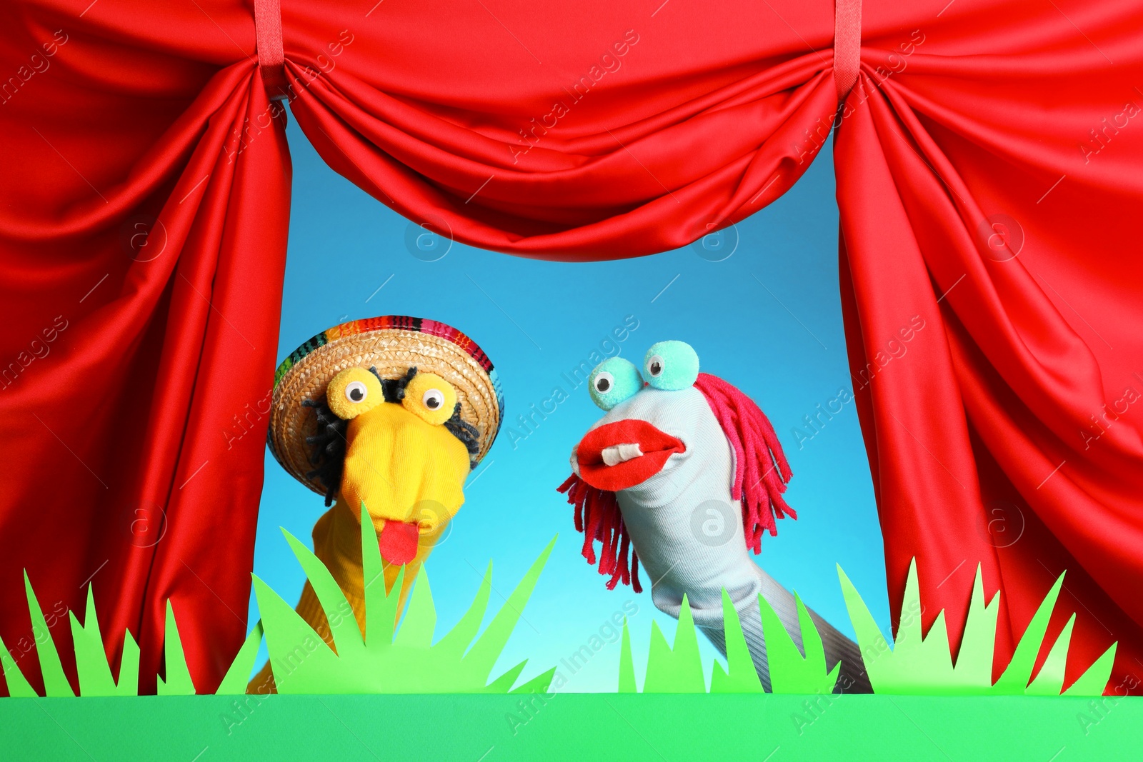 Creative puppet show on stage with decorations and red curtains Photo of Creative puppet show on stage with decorations and red curtains