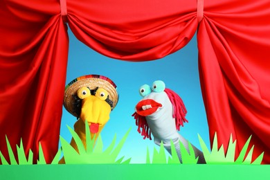 Photo of Creative puppet show on stage with decorations and red curtains