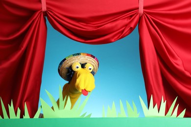 Photo of Creative puppet show on stage with decorations and red curtains