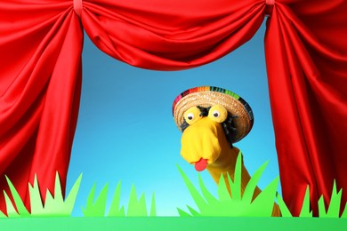 Photo of Creative puppet show on stage with decorations and red curtains