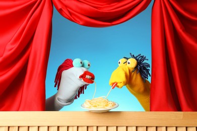 Photo of Creative puppet show on wooden stage with prop and red curtains