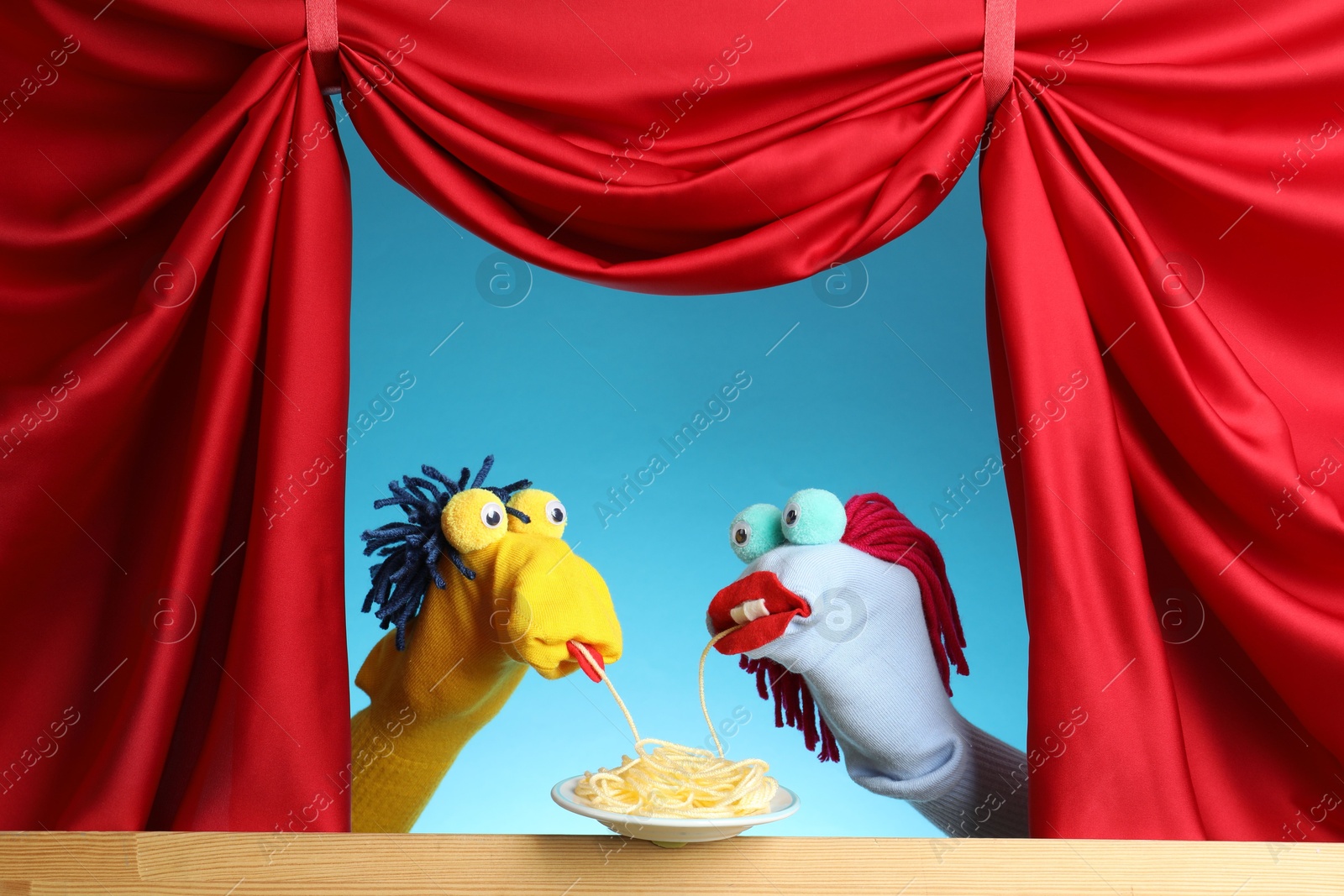 Creative puppet show on wooden stage with prop and red curtains Photo of Creative puppet show on wooden stage with prop and red curtains