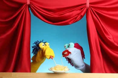 Photo of Creative puppet show on wooden stage with prop and red curtains