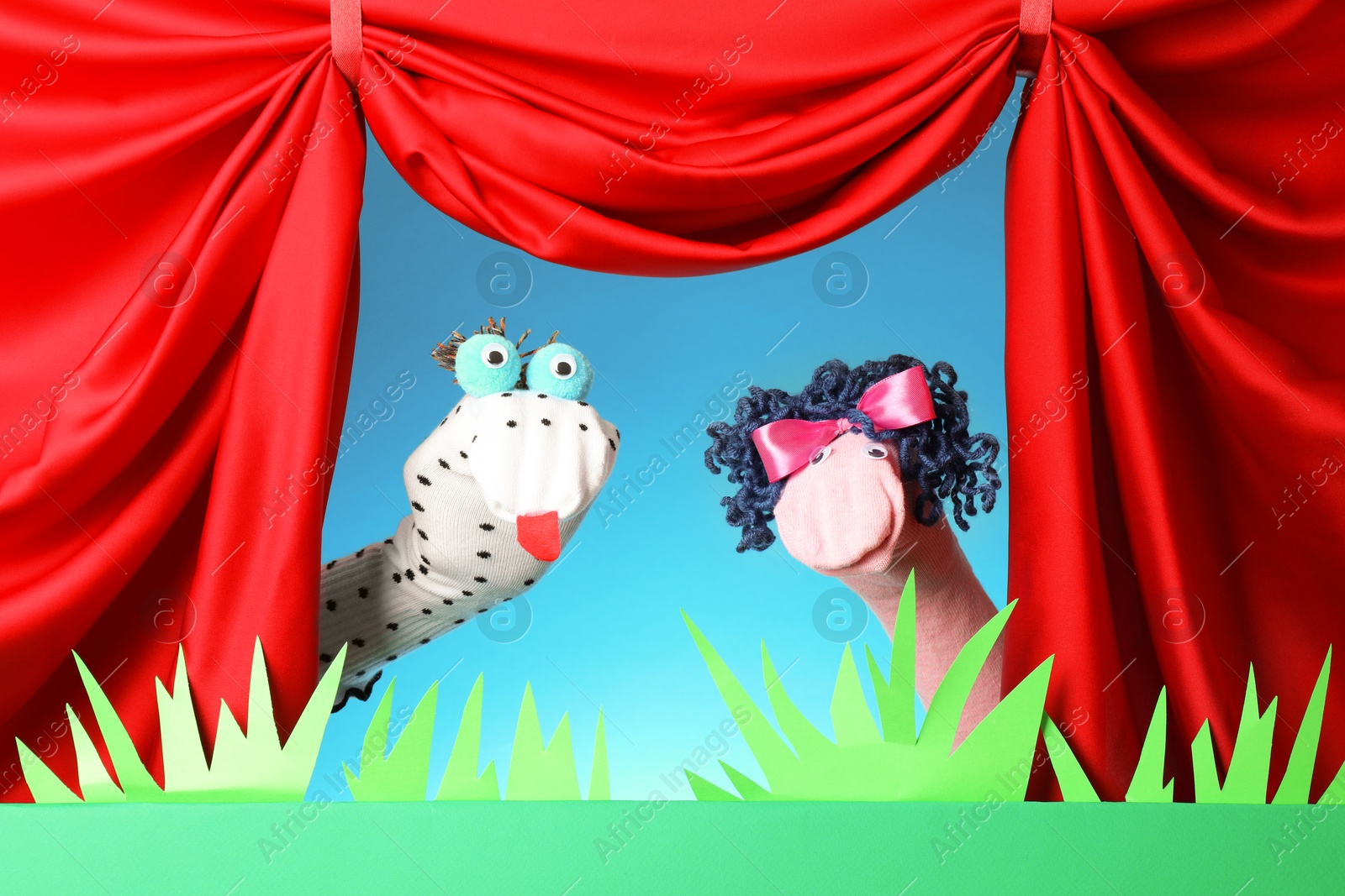 Creative puppet show on stage with decorations and red curtains Photo of Creative puppet show on stage with decorations and red curtains