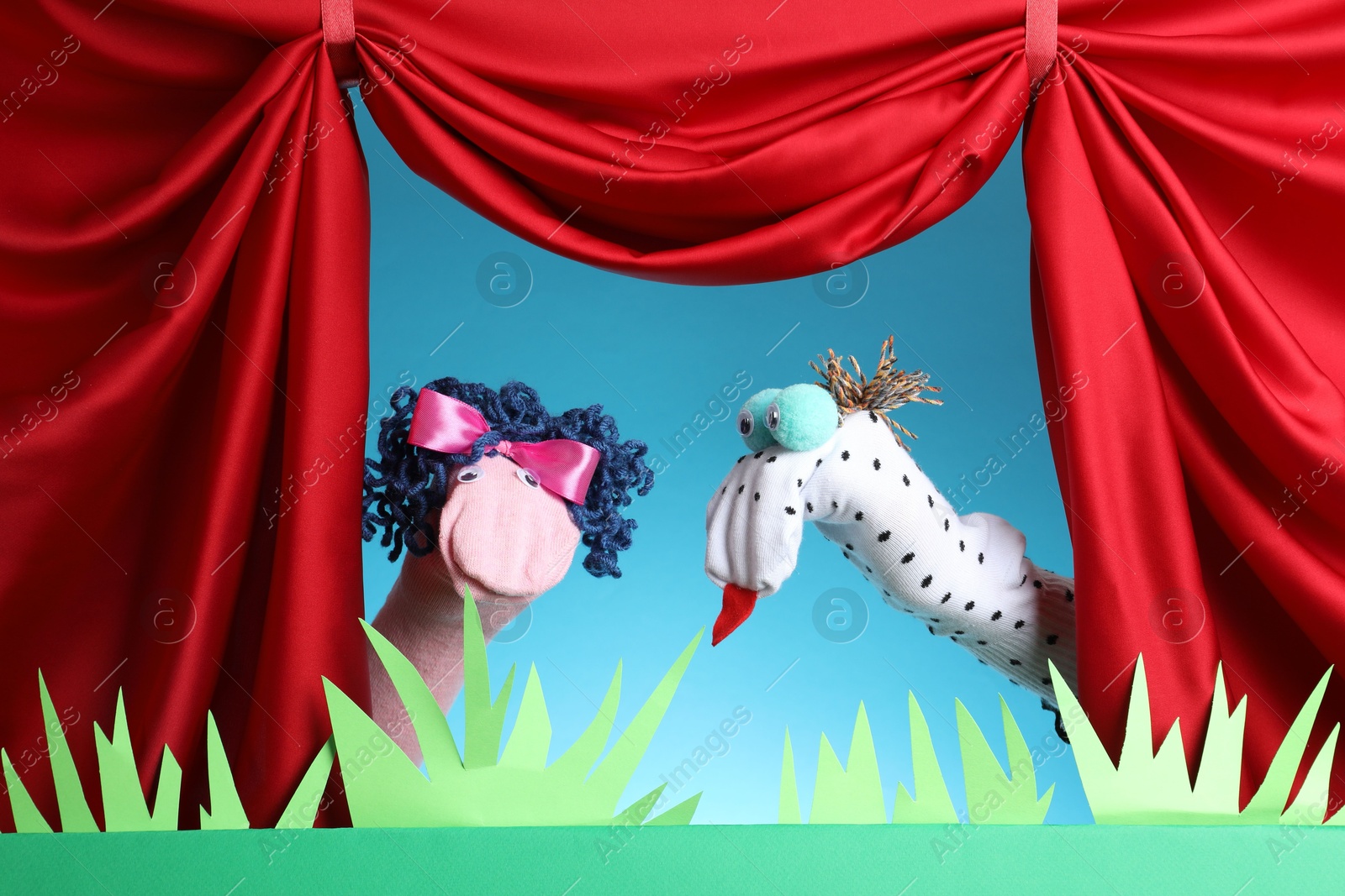 Creative puppet show on stage with decorations and red curtains Photo of Creative puppet show on stage with decorations and red curtains