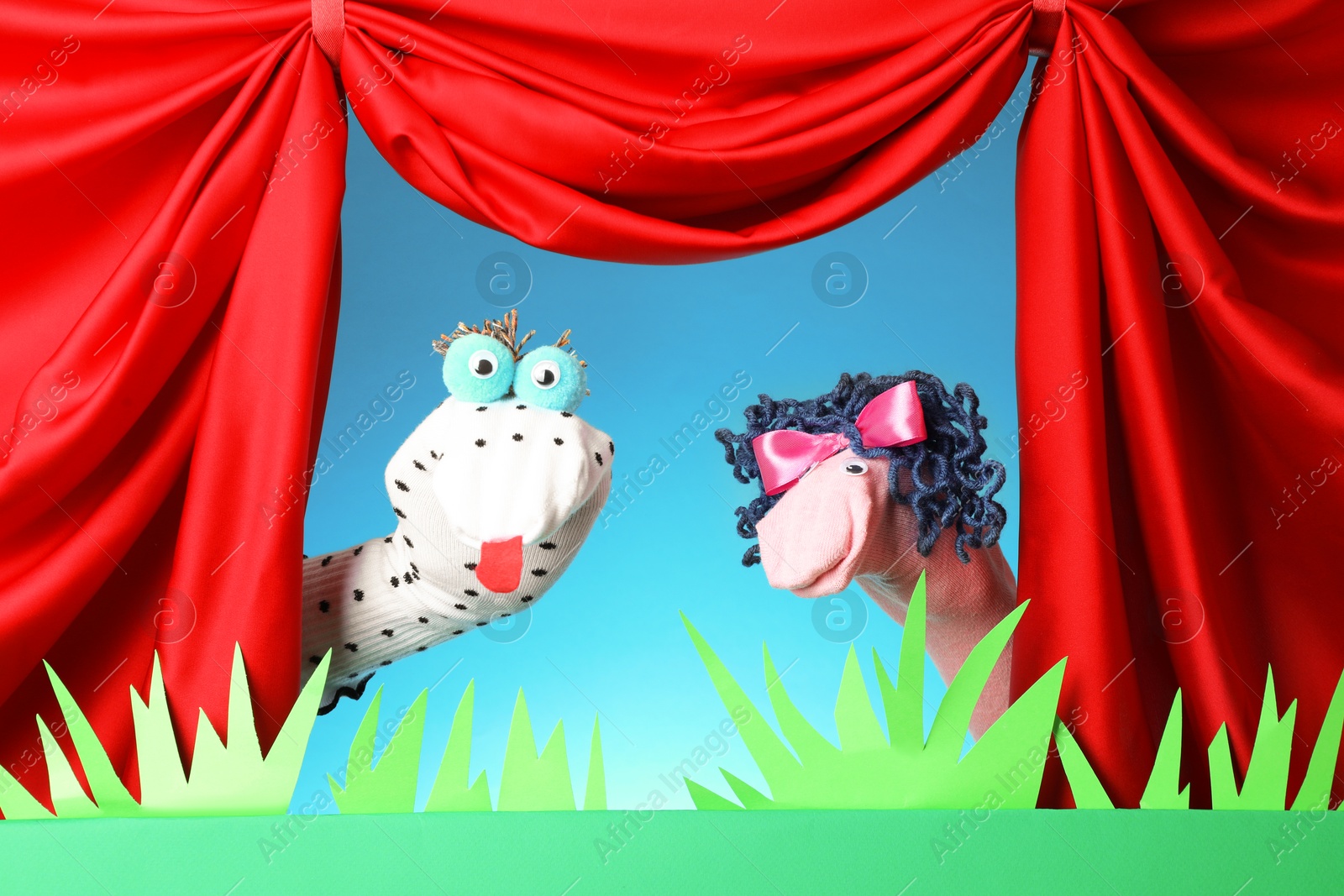 Creative puppet show on stage with decorations and red curtains Photo of Creative puppet show on stage with decorations and red curtains