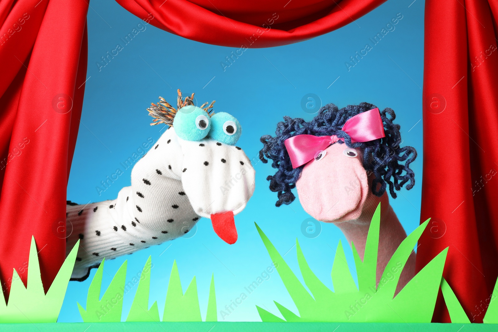 Creative puppet show on stage with decorations and red curtains Photo of Creative puppet show on stage with decorations and red curtains