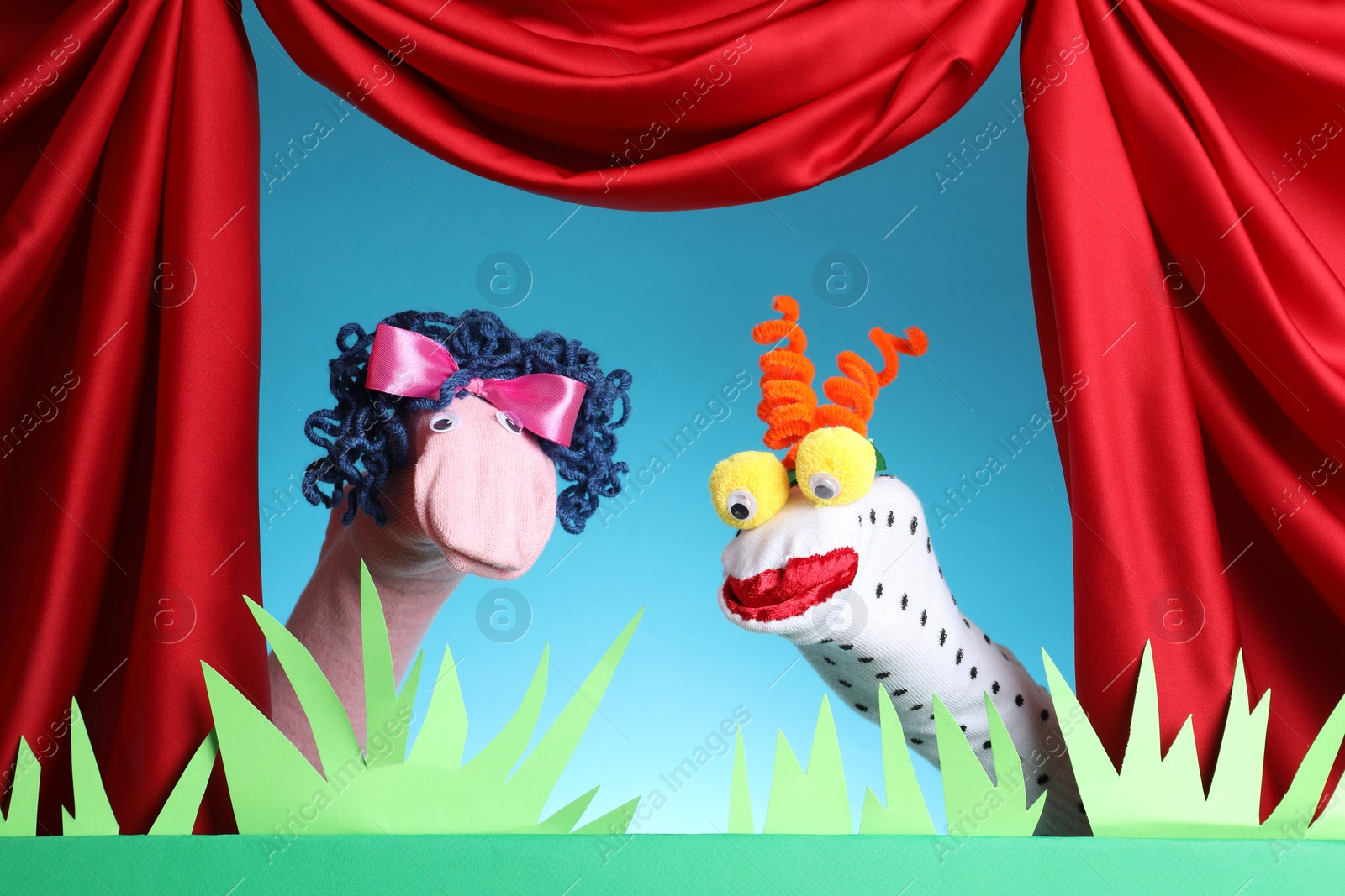 Creative puppet show on stage with decorations and red curtains Photo of Creative puppet show on stage with decorations and red curtains