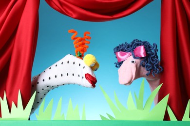 Photo of Creative puppet show on stage with decorations and red curtains