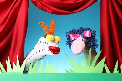 Photo of Creative puppet show on stage with decorations and red curtains