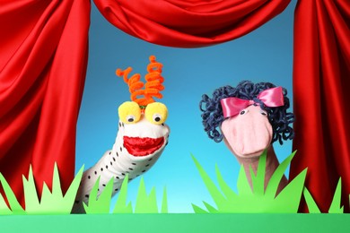 Photo of Creative puppet show on stage with decorations and red curtains