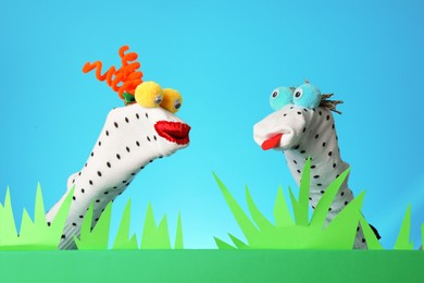 Photo of Creative puppet show on stage with decorations against light blue background