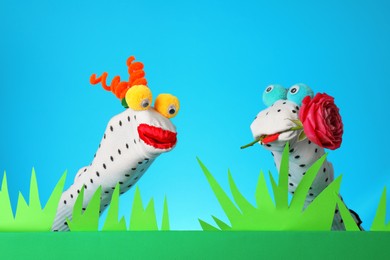Photo of Creative puppet show on stage with prop and decorations against light blue background