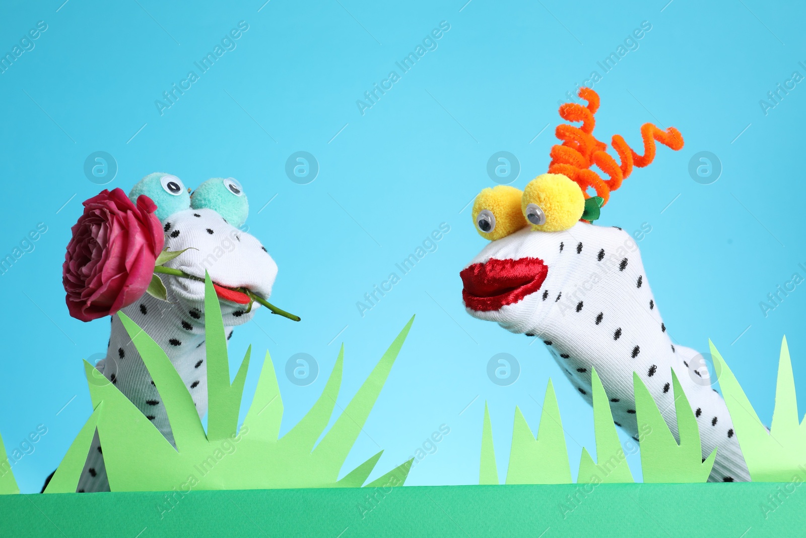 Photo of Creative puppet show on stage with prop and decorations against light blue background