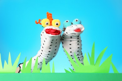 Photo of Creative puppet show on stage with decorations against light blue background