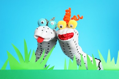 Photo of Creative puppet show on stage with decorations against light blue background