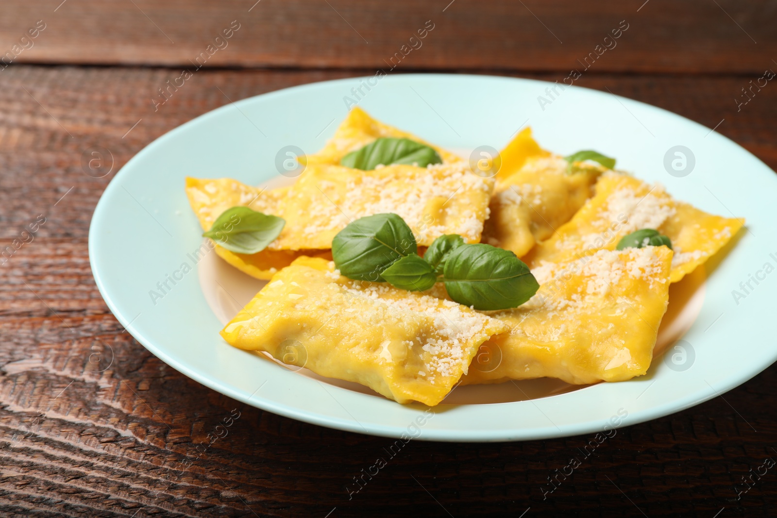 Delicious ravioli with cheese and basil on wooden table, closeup Photo of Delicious ravioli with cheese and basil on wooden table, closeup