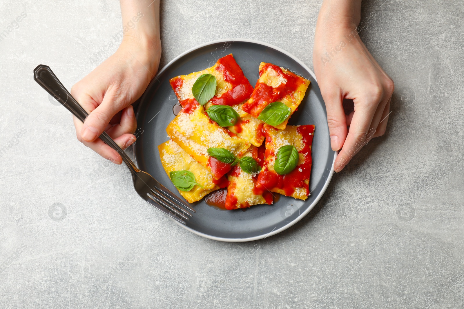Woman eating delicious ravioli at grey table, top view Photo of Woman eating delicious ravioli at grey table, top view