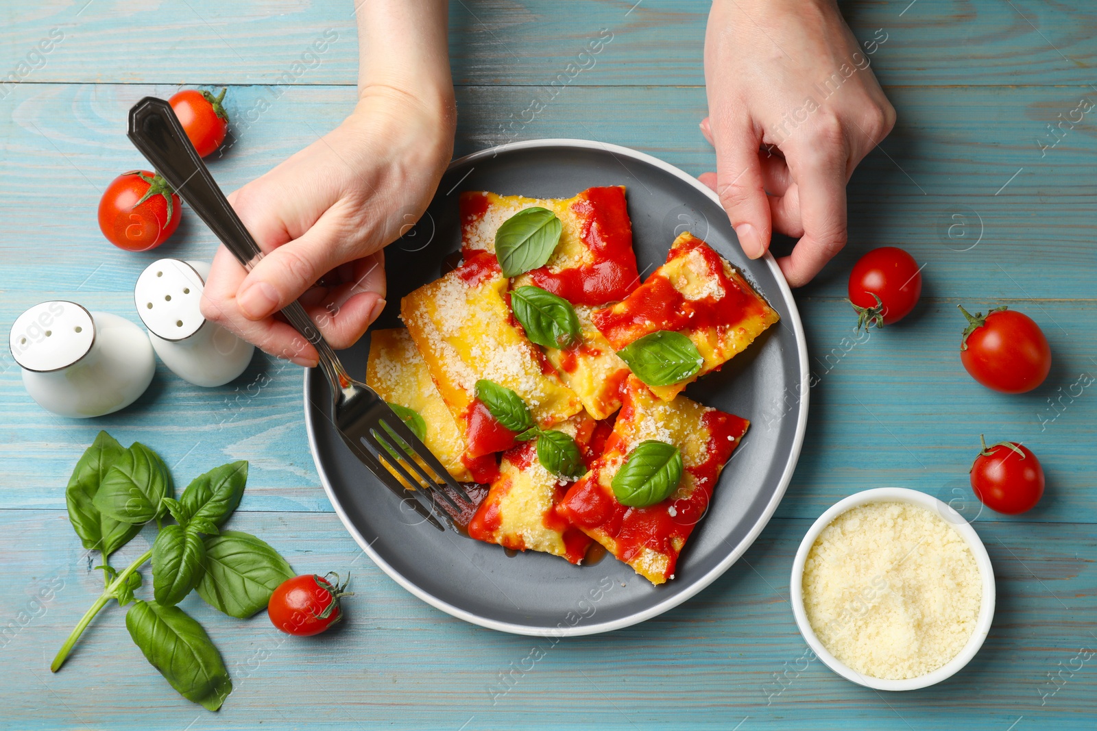 Woman eating delicious ravioli at blue wooden table, top view Photo of Woman eating delicious ravioli at blue wooden table, top view
