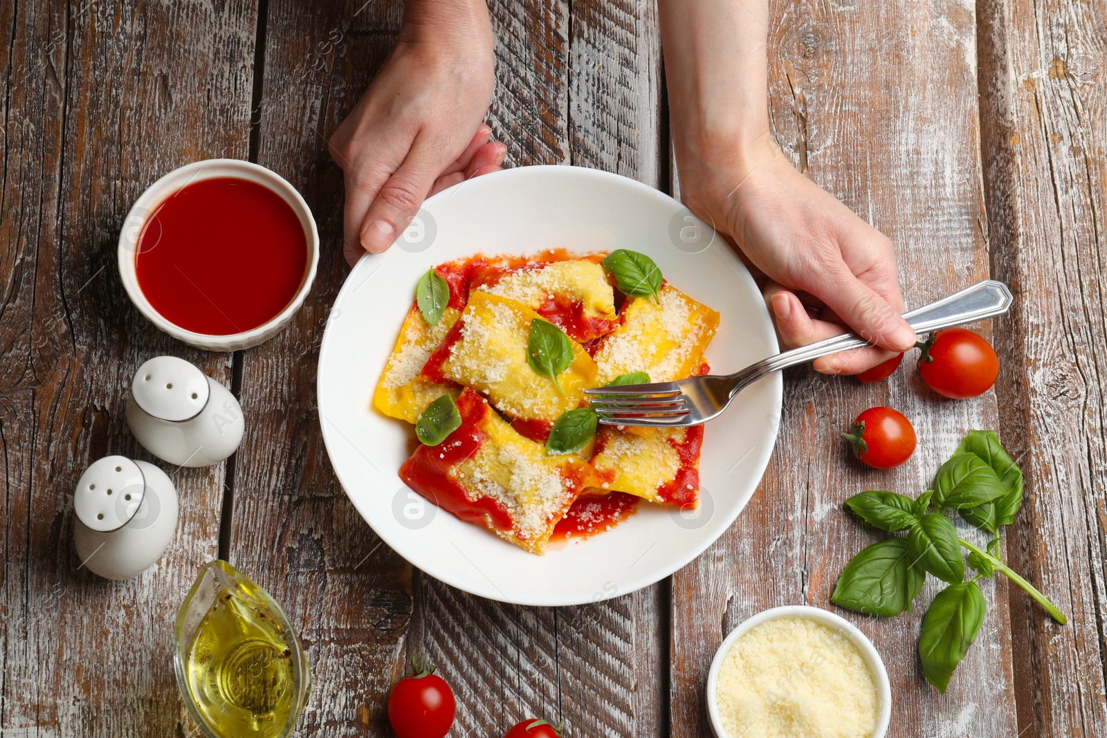 Woman eating delicious ravioli at wooden table, top view Photo of Woman eating delicious ravioli at wooden table, top view