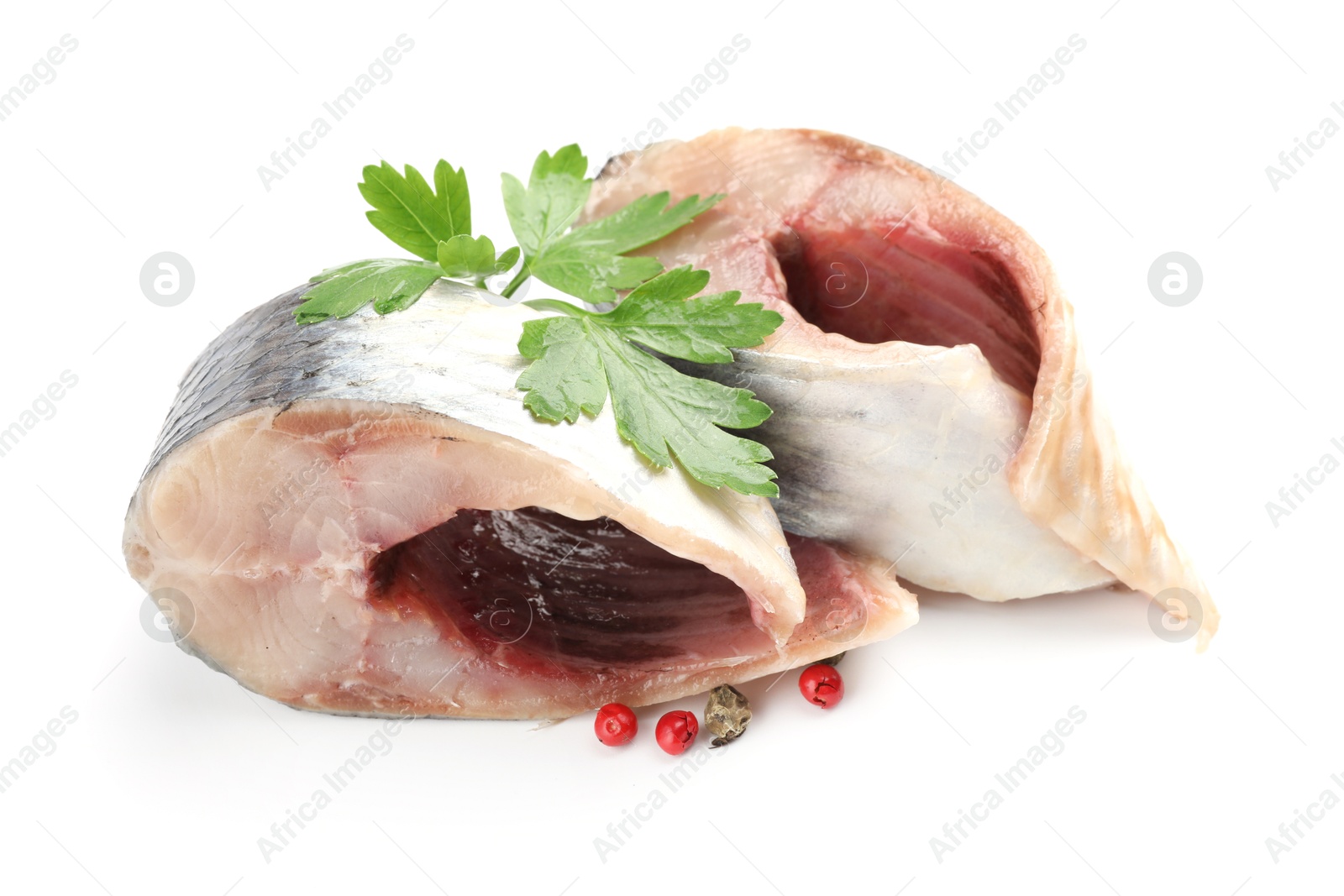 Pieces of delicious herring with peppercorns and parsley isolated on white Photo of Pieces of delicious herring with peppercorns and parsley isolated on white