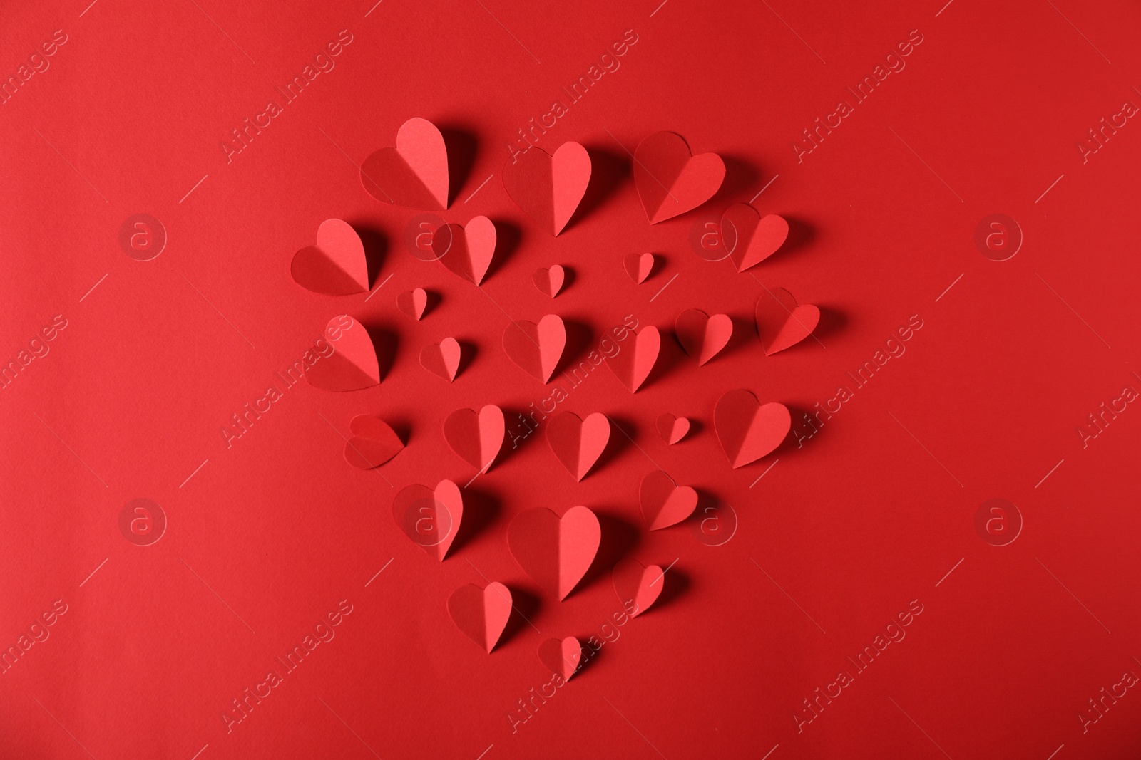 Many paper hearts on red background, flat lay Photo of Many paper hearts on red background, flat lay