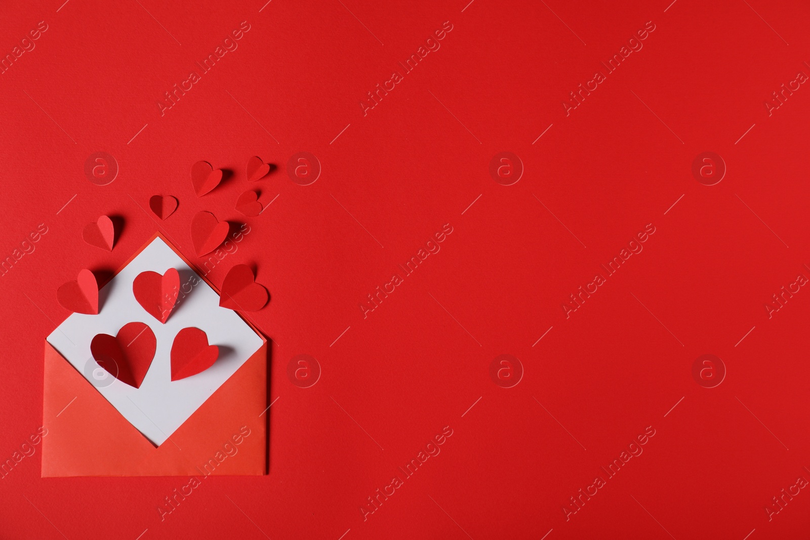 Paper hearts flying out of envelope on red background, flat lay. Space for text Photo of Paper hearts flying out of envelope on red background, flat lay. Space for text