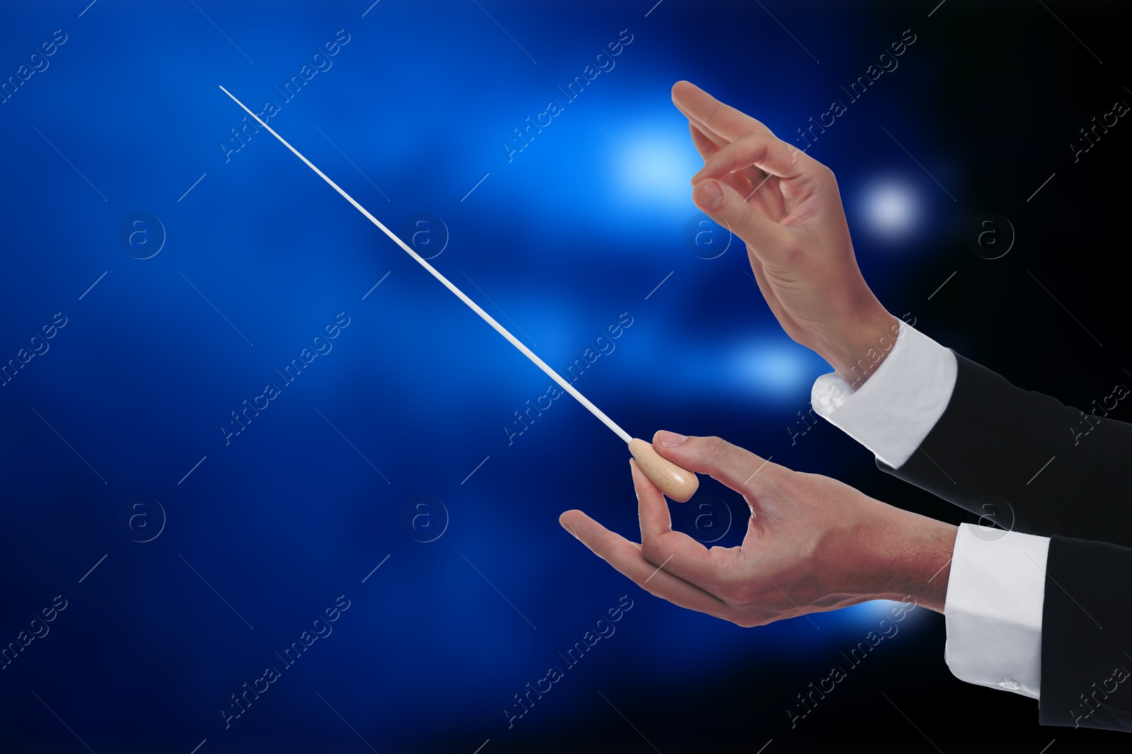 Conductor with baton in concert hall, closeup Image of Conductor with baton in concert hall, closeup
