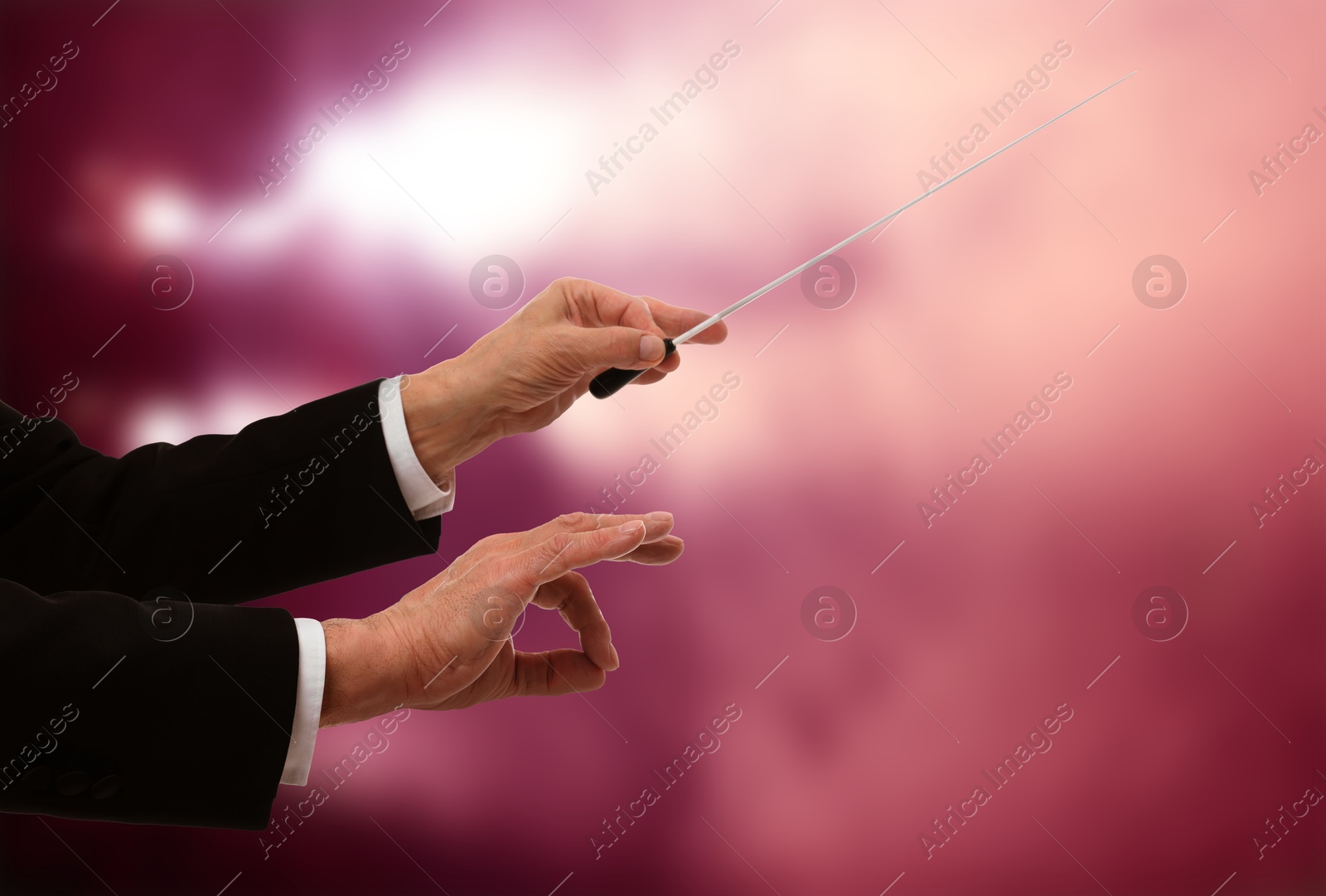 Conductor with baton in concert hall, closeup. Space for text Image of Conductor with baton in concert hall, closeup. Space for text