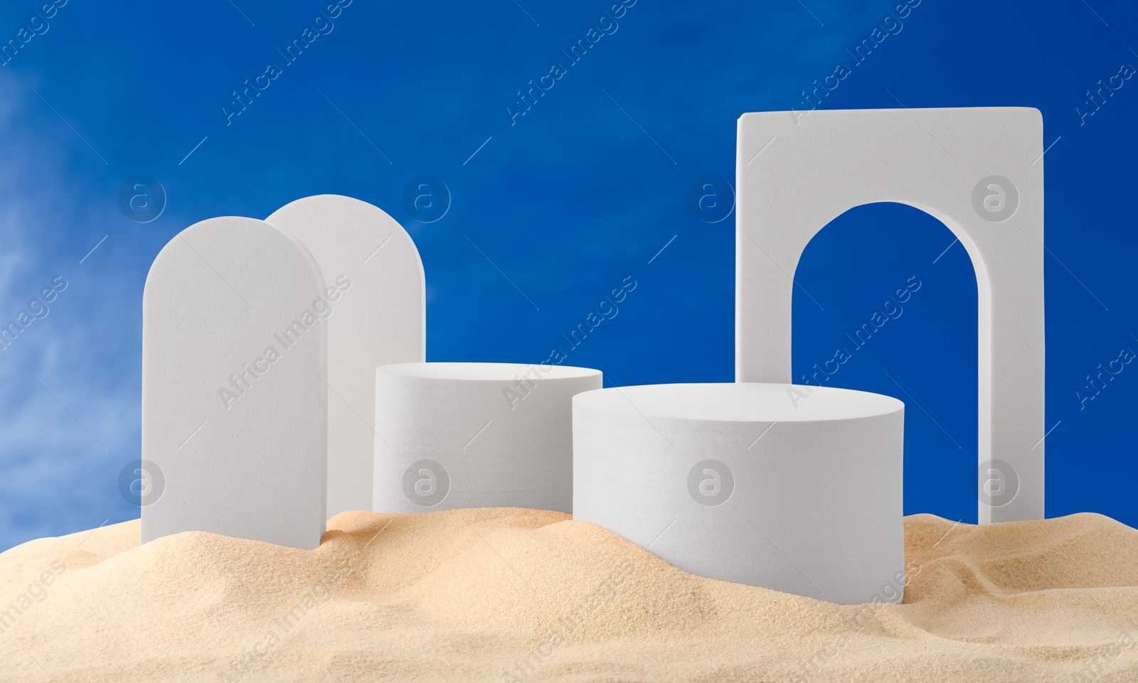 White podiums and figures in sand against blue sky, banner design Image of White podiums and figures in sand against blue sky, banner design