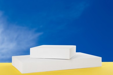 Image of White podium on yellow board against blue sky
