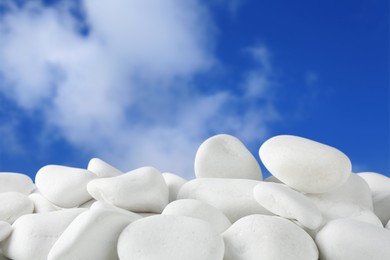 Image of White pebbles against blue sky with clouds
