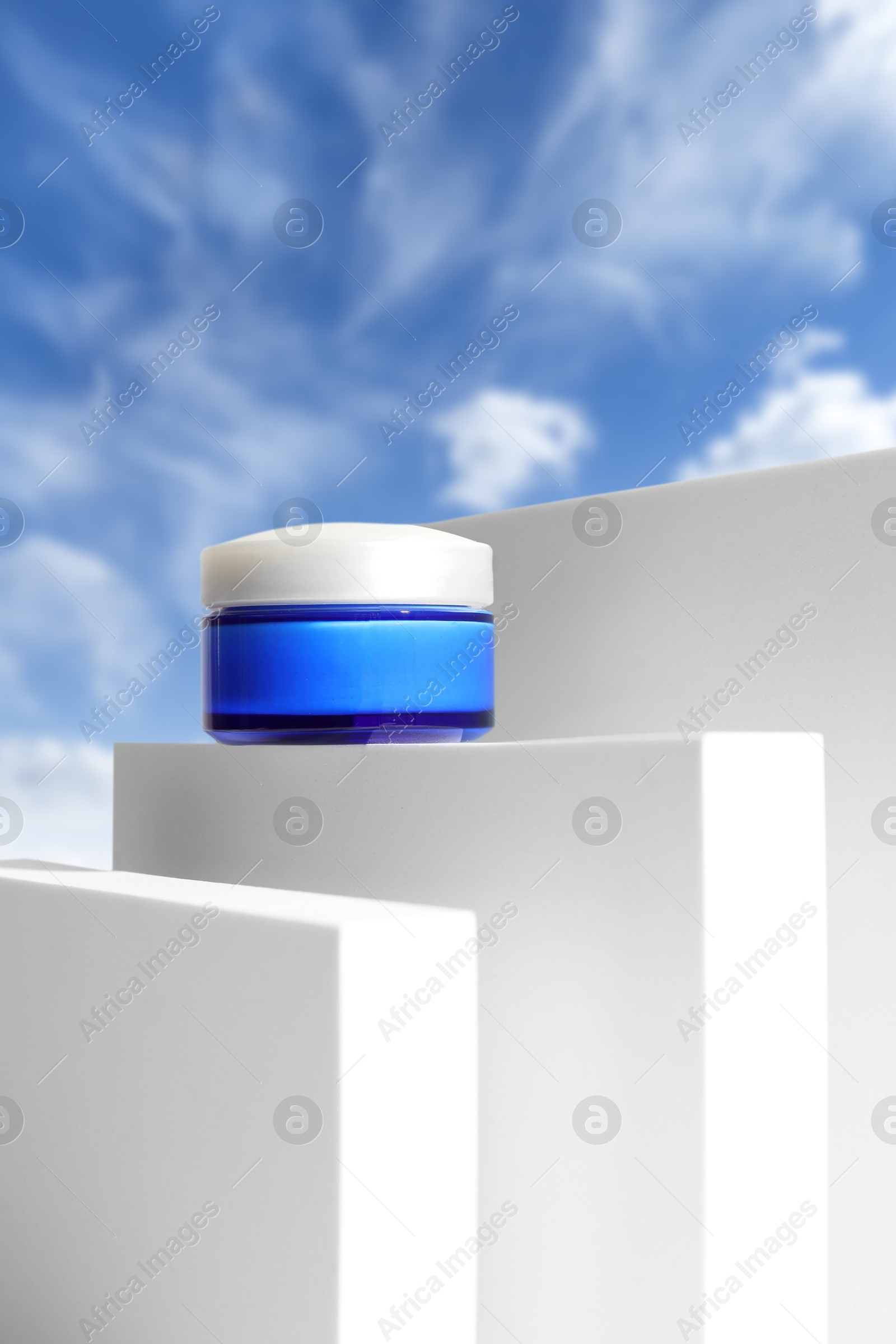 Cream on white podium against blue sky Image of Cream on white podium against blue sky