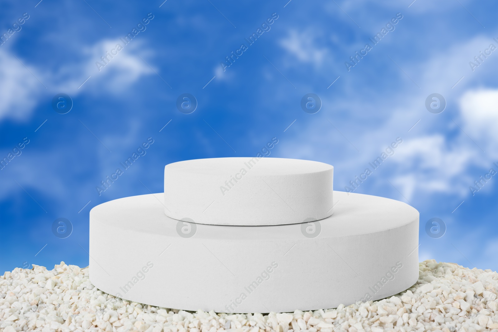 White podium on small stones against blue sky Image of White podium on small stones against blue sky