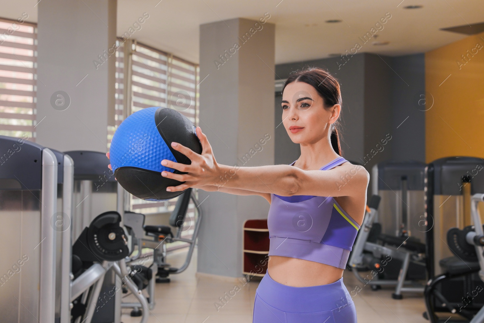 Young woman exercising with medicine ball in gym Photo of Young woman exercising with medicine ball in gym