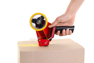 Photo of Man using dispenser with adhesive tape to seal cardboard box on white background, closeup
