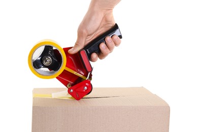 Photo of Man using dispenser with adhesive tape to seal cardboard box on white background, closeup