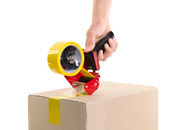 Photo of Man using dispenser with adhesive tape to seal cardboard box on white background, closeup