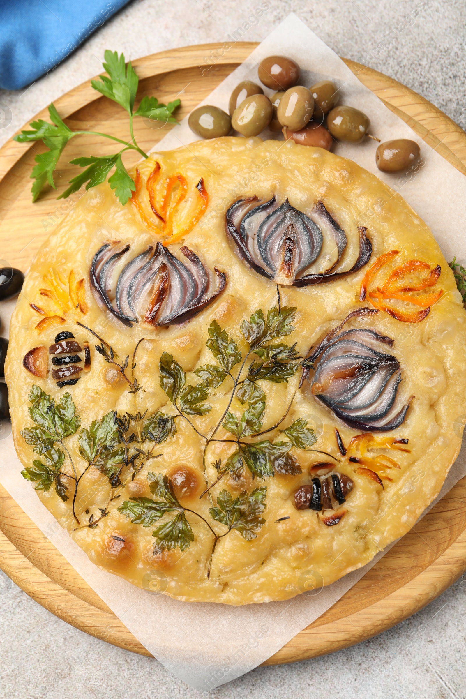 Delicious focaccia with flowers made of vegetables on grey table, top view Photo of Delicious focaccia with flowers made of vegetables on grey table, top view